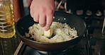 Cooking, meal and hands of man in kitchen for recipe, culinary skills and pan on stove. Person, butter and rice in dish for preparation, risotto process and chef in home for private class in cuisine