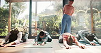 Yoga, instructor and group with stretching in class for flexibility, holistic wellness and body balance on floor. Studio, people and pilates with technique for fitness, mindfulness and spiritual zen