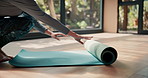 Woman, hands and yoga with mat on floor for pialtes, exercise or indoor workout at home. Female person, legs or yogi rolling training mat for start, warm up or getting ready to stretch at health club