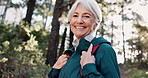 Face, forest and senior woman hiking for travel, holiday or vacation outdoor. Portrait, smile and person trekking in woods for adventure, journey and retirement hobby to explore Canada for tourism