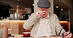 Glasses, senior man and eye strain of reading in cafe with brain fog, vertigo and blurred vision of glaucoma. Elderly, person and tension of spectacles in restaurant with book, migraine and pressure