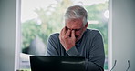 Senior, frustrated man and laptop with headache for financial crisis, loss or debt review at home. Mature, male person or stress with computer for finance, mistake or struggle on computer at house