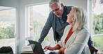 Paperwork, laptop and senior couple with discussion at table for loan, financial bills and insurance. Elderly people, retirement and talking at home for pension, healthcare debt and invoice payment