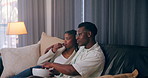 House, popcorn and black couple on sofa, entertainment and watching tv in living room. African man, woman and rest on couch, comfortable and hobby with movie, love or series with fun and relationship