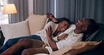 Home, funny and black couple with love, entertainment and watching tv in living room. African man, woman and laughing on sofa, comfort or hobby with movie, joke and series with relationship or comedy