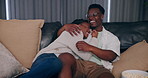 Laugh, happy and watching tv with black couple play fighting on sofa for streaming, subscription or date night. Remote, marriage and movie with man and woman at home for broadcast, show or film media