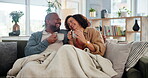 Couple, blanket and talking with coffee, living room and listening to joke, mature man and woman in home. Lounge, laughing and bonding of people, tea and conversation of love in relationship in house