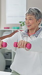 Senior woman, physiotherapy and dumbbells with support for recovery, exercise or muscle development. Elderly patient, physiotherapist and weight training for rehabilitation, injury or happy at clinic