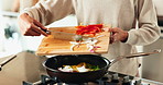 Hands, person and cooking with vegetables in kitchen for meal prep, health lunch and nutrition of morning breakfast. Chef, wood board and pan for food process, salad ingredients and vegan at house