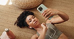 Phone, earphones and woman relax on floor in home listening to music with research for chakra. Calm, cellphone and female person streaming playlist with audio tech for mindfulness, peace and rest.