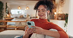 Woman, smile and texting with phone on sofa for dating app, response and online communication. Female person, happy and typing with tech at home for platform, profile match and digital conversation