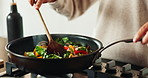 Hands, spoon and cooking in house for brunch, eating and health with nutrition, flavor and stir fry. Frying, dinner and person in kitchen for healthy breakfast, meal prep or food with diet in morning