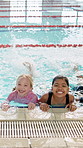 Girl, children and face in pool for swimming lesson with smile, kick and splash with diversity. Kids, friends and happy in water with exercise, learning and start class with development in Brazil