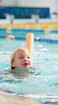 Girl, child and noodle in swimming pool for lesson, stroke and excited with development, wellness or training. Kid, exercise and fitness at class with safety, progress and timelapse for water sports