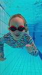 Swimming, underwater and wave with child in pool for wellness, learning and water sports. Happiness, summer and exercise with girl in aquatic center for education, development and competition