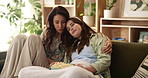 Couple, lesbian and hug in house for movie, television and streaming online video with film subscription. Women, popcorn and eating snack in living room for watching tv, bonding or relax with blanket