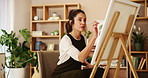 Woman, painting and work as artist in studio for design, project or home decor as handmade craft. Female person, serious and pride as creative in small business or workshop as painter for art gallery