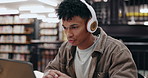 Student, headphones and man reading on laptop in library for education, university and knowledge. College, music and person on technology for studying research for project assignment and assessment