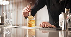 Bartender, person and drink with cocktail in glass for event, catering and hospitality service. Professional, server and hands pouring alcohol with utensil for restaurant, mixology or preparing order