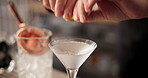 Hands, bartender and martini in glass for mixology, alcohol and hospitality with catering in club. Barman, drinks and cocktail in hotel for happy hour, preparation and professional person with lemon