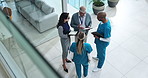 Doctors, group and discussion in lobby at hospital with paperwork, tablet and above for healthcare service. Clinic director, staff and team in scrum for meeting with documents, feedback or inspection