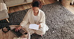 Woman, student and laptop with documents on floor for planning, thinking and typing with research for thesis. Person, girl and computer with reading, study and above for elearning on carpet in home