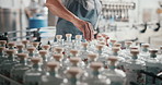 Hands, man and packaging alcohol at distillery with gin bottles for manufacturing and production at warehouse. Male person, business and employee with stocktaking at factory for delivery and supply