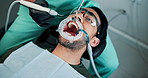 Dental dam, tools and exam with man in clinic for healthcare, cleaning and teeth whitening. Consulting, orthodontist and oral screening with dentist and patient for fluoride treatment and medicine