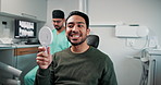 Dentist, mirror and man checking smile for results, veneers or mouth care at medical clinic. Healthcare, confidence and happy patient in dental chair for cleaning, health or teeth whitening treatment