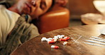 Man, sleeping or pills with drugs for substance abuse, overdose or cocaine on sofa at house party. Young, male person or addict asleep on couch with tablets, medication or narcotic addiction for pain