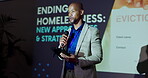 Talking, tablet and man with mic, seminar and speech for ending of homelessness, stage and event. Workshop, presentation and public speaking in conference, communication and black person with pitch