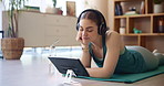 Woman, relax and streaming with tablet for yoga, home practice and spirituality on exercise mat. Girl, tech and watching for wellness, zen or meditation for rest in house for health, balance or peace