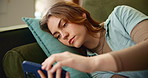 Online, tired and bored woman on sofa with phone for website, internet or social media at home. Scroll, communication and student laying on couch with smartphone, app and entertainment in living room