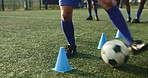 Legs, person and ball with cone for soccer of fitness practice, running guide and exercise performance. Athlete, beacon and warm up challenge with sports football, agile and game training on field