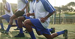 Legs, stretching and soccer team outdoor on sport field with training, wellness and pitch warm up. Workout, game and people in group with health, exercise and fitness of athlete friends at club