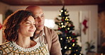 Christmas, love and couple dance in home to celebrate festive holiday together. Xmas, man and happy woman moving to romantic music in living room for care, support and bonding with bokeh at night