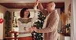 Couple, home and happy with dancing on Christmas for fun, break and celebration as lovers. Relationship, people and smile with bonding in living room on festive season for unity, love and support