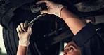 Woman, wrench and suspension for car repair, transmission and vehicle maintenance in garage. Mechanic, tools and drivetrain for road safety, performance and inspection service in automobile workshop