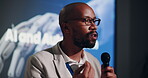 Talking, seminar and black man with mic, stage and discussion of Ai and automation in presentation. Workshop, public speaking and explaining to people, event and ethics for system and industry