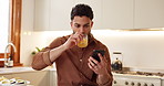 Kitchen, orange juice and man with smartphone, typing and chatting with internet, healthy drink and morning routine. Person, apartment and guy with cellphone, nutrition and digital app for diet plan