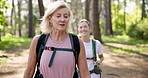 Mom, daughter and hiking with backpack in forest for fitness adventure, talking and bonding in nature. Mature woman, girl and laughing with trekking in woods for cardio exercise, explore and walking