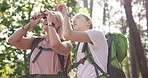 Woman, mother and binoculars for travel, adventure or birdwatching in nature, park or forest. Smile, mature parent and tourist with journey for research, holiday or vacation in woods for bonding