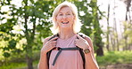 Mature, happy woman and hiker with backpack in forest for hiking, adventure or outdoor journey. Portrait, senior or female person with smile in joy for travel bag, walk or sightseeing in nature