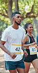 Running, nature and group of people in marathon for outdoor exercise, competition or fitness. Sports, energy and community of athletes with cardio workout in race with crowd for contest in park.