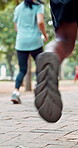 Running, marathon and shoes with people in city for sports, fitness challenge and workout. Performance, wellness and athlete race with runner training in park for competition, exercise and speed