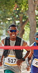 Running, finish line and black men in marathon in nature with group for outdoor exercise, competition or fitness. Sports, energy and male athletes with cardio workout in race for contest in park.