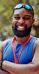 Medal, crossed arms and face of black man at marathon in nature with pride for fitness goal or achievement. Happy, win and portrait of African athlete with gold award for race with cardio exercise.