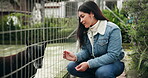 Happy, woman and shelter for animal adoption with volunteer service, homeless dogs and rescue centre. Smile, female person and relax by fence with safety, foster care and pet welfare for charity ngo