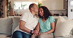 Holding hands, kiss and smile with mature couple on sofa in living room of home together for bonding. Love, relax or wellness with happy man and woman in apartment for relationship or romance