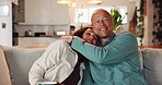 Hugging, kiss and smile with mature couple on sofa in living room of home together for bonding. Happy, relax or wellness with man and woman embracing in apartment for love, relationship or romance